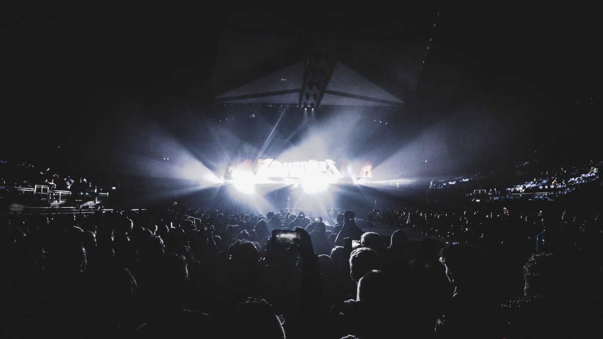A large crowd at a night-time arena concert in London, lit by stage lighting